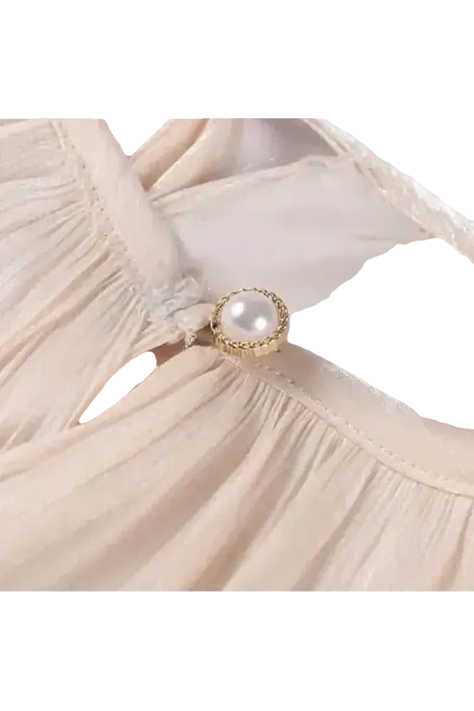 Detailansicht des Éloïse Plissee Kleids mit elegantem Knopf und plissiertem Stoff.