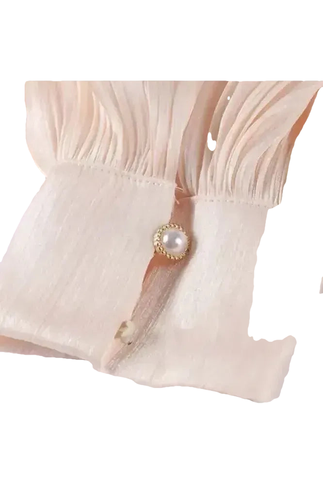 Detailaufnahme des Éloïse Plissee Kleids mit elegantem Plisseestoff und Perlenknopf.