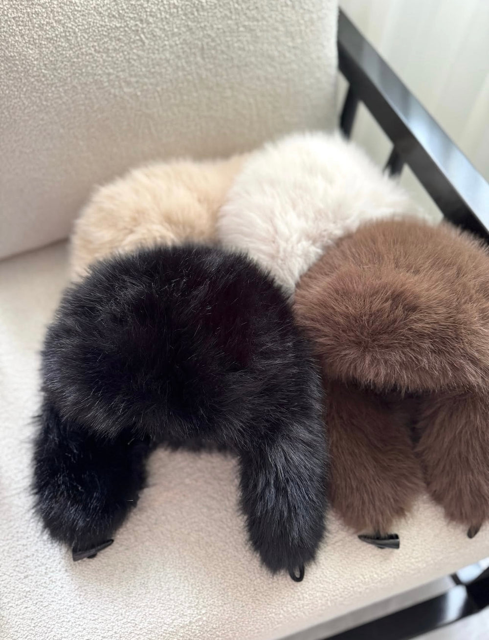 ISABELLE - Elegant Beanie – verschiedene Farben auf einem Stuhl, stylisches Accessoire für kalte Tage.