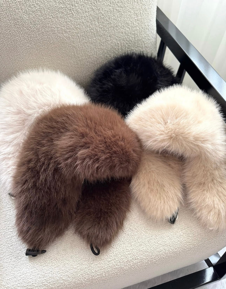 ISABELLE - Elegant Beanie in various colors displayed on a chair, perfect for stylish winter outfits.