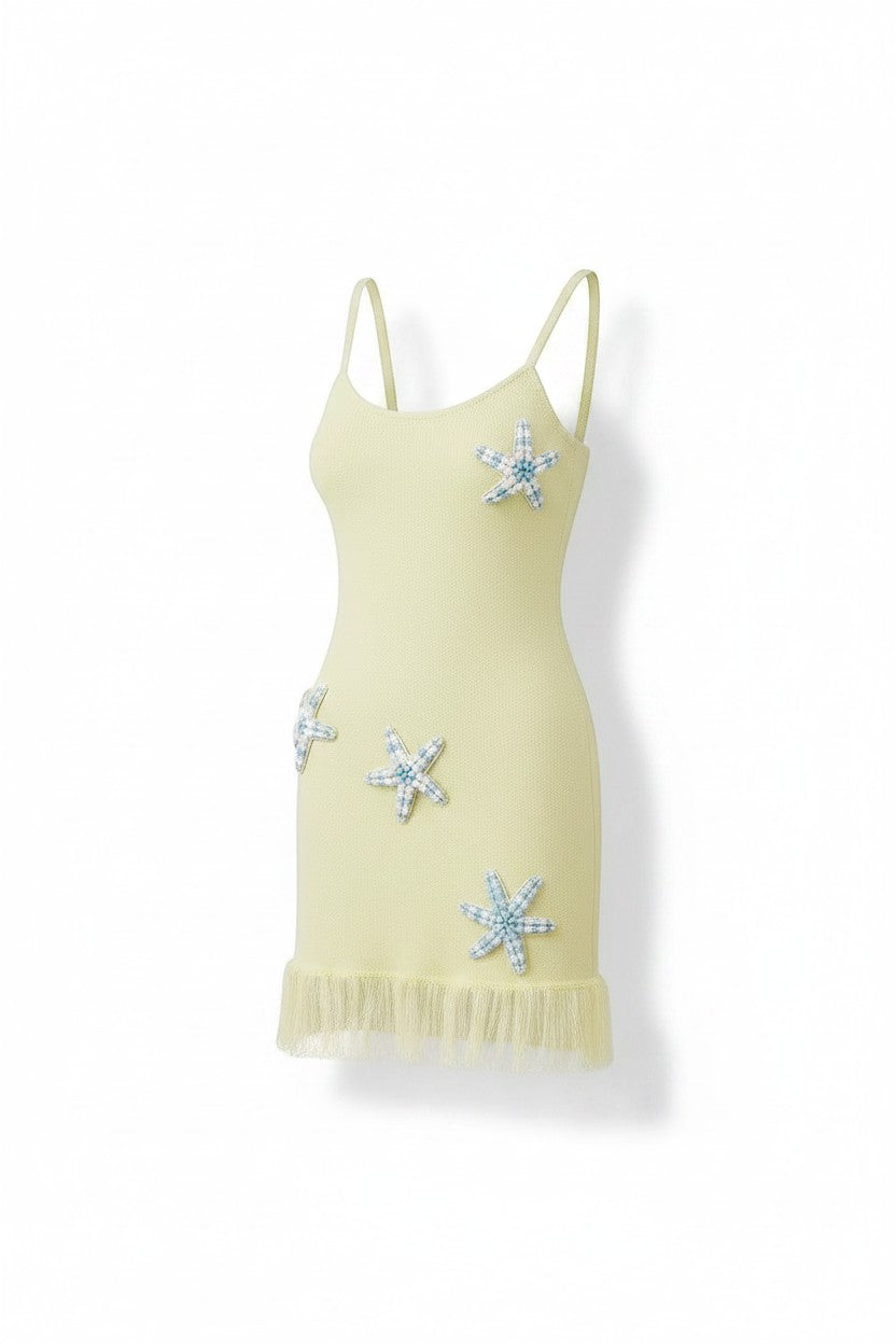Miraee Paris lemon cream knit mini dress with spaghetti straps, starfish appliques, and ruffled hem.