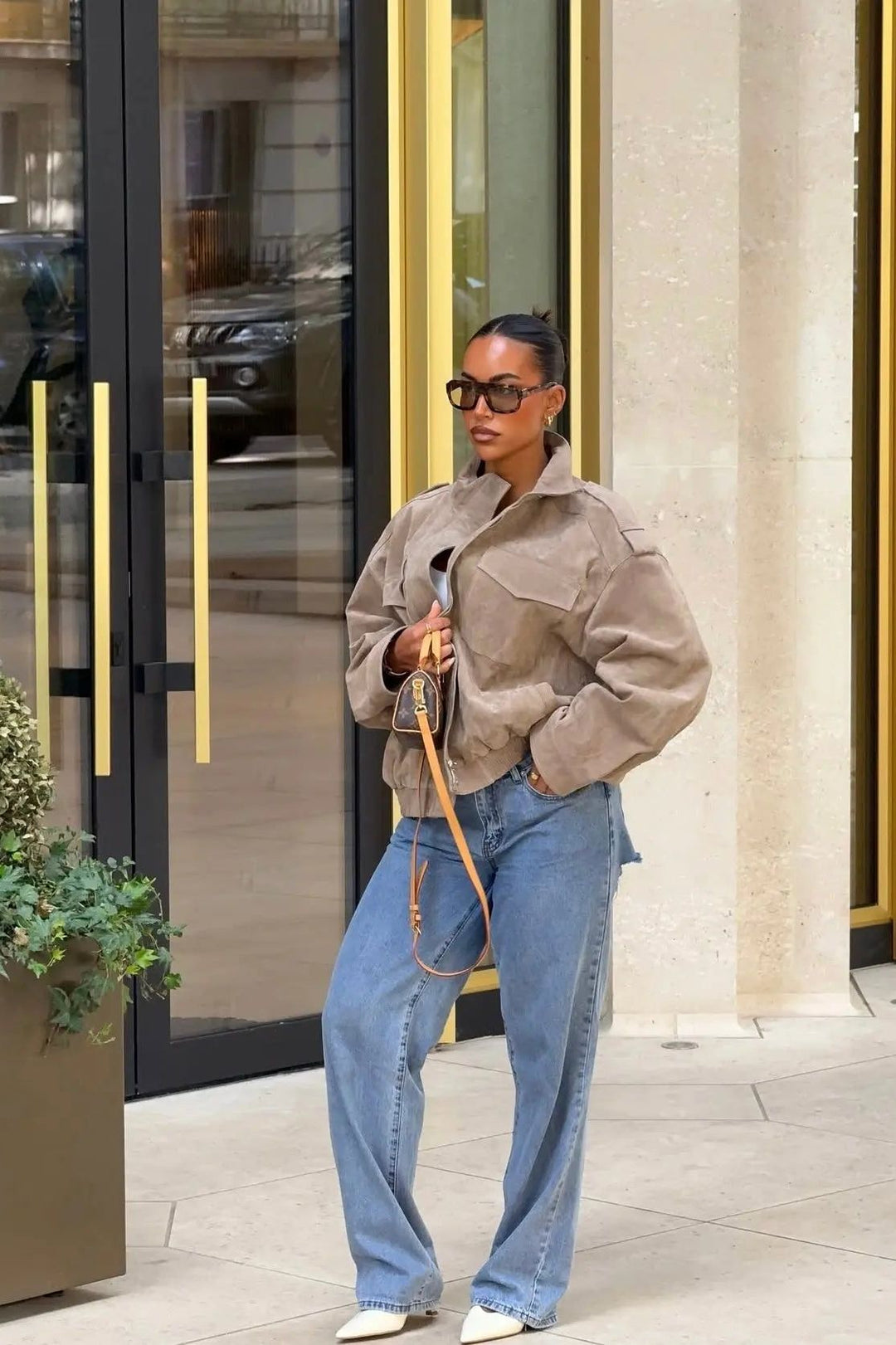 Exklusive Lederjacke im Utility-Design, kombiniert mit lässigen Jeans und Sonnenbrille, urbane Eleganz im Streetstyle.