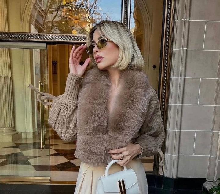 LUMINA – Winter Cardigan mit Kunstpelzkragen kombiniert mit eleganten Accessoires in einer stilvollen Umgebung.