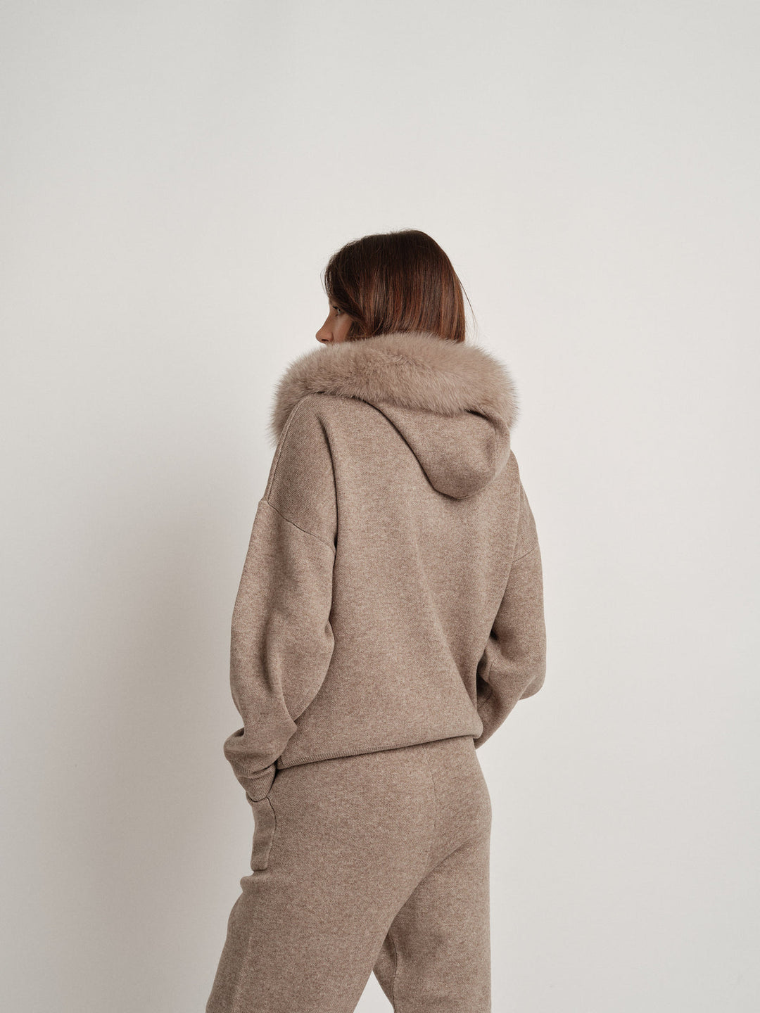 Dame trägt das Bella Cashmere Lounge Set mit luxuriösem Fellbesatz, perfekt für entspannte Tage und stilvolle Casual-Outfits.