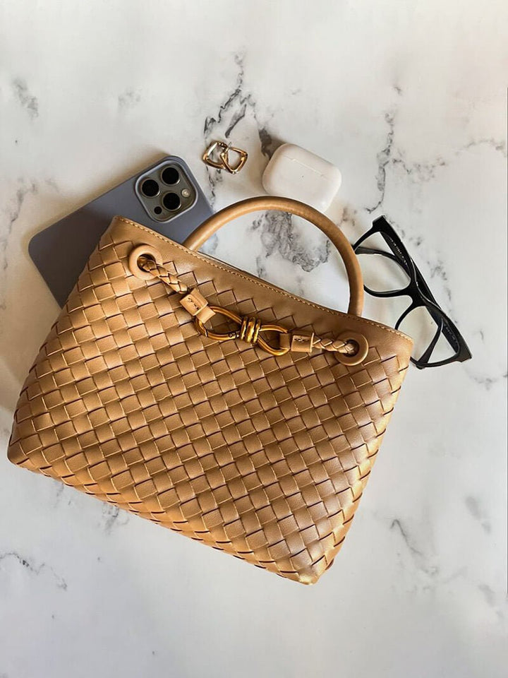 CELIA LARGE – Luxus Ledertasche auf Marmoroberfläche, umgeben von Brille und Smartphone.