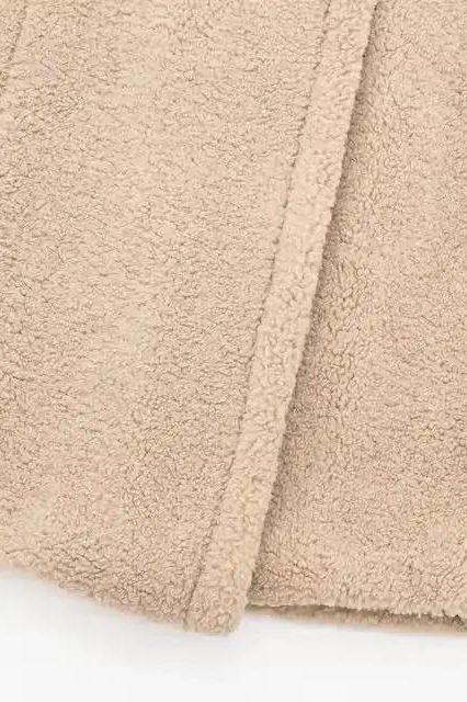 Nahaufnahme des flauschigen Kunstpelzes des BERNA – Luxuriöser Oversized Teddymantel in Beige.