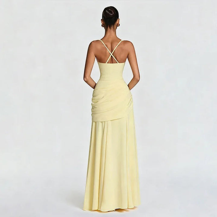 Miraee Paris backless yellow maxi dress with draped detailing and crisscross straps for an elegant evening look.